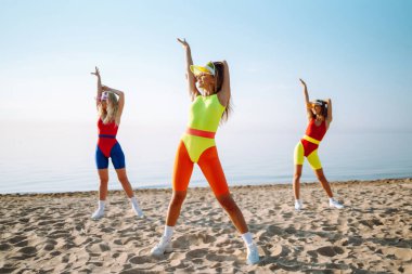 Sokakta dans eden mayolu üç genç kadın. Aktif spor. Fitness, dans ve şehir kültürü konsepti