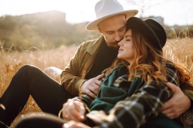 Stylish couple walking and hugging in the park. People, lifestyle, relaxation and vacations concept. Autumn Fashion, style concept.