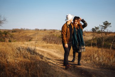 Stylish couple walking and hugging in the park. People, lifestyle, relaxation and vacations concept. Autumn Fashion, style concept.