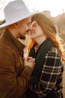 Stylish couple walking and hugging in the park. People, lifestyle, relaxation and vacations concept. Autumn Fashion, style concept.