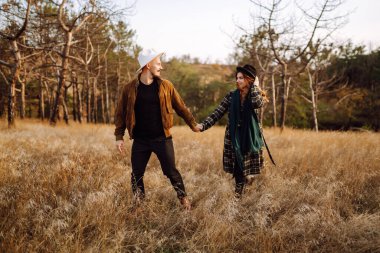Stylish couple walking and hugging in the park. People, lifestyle, relaxation and vacations concept. Autumn Fashion, style concept.