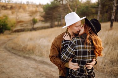 Stylish couple walking and hugging in the park. People, lifestyle, relaxation and vacations concept. Autumn Fashion, style concept.