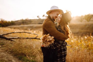 Stylish couple walking and hugging in the park. People, lifestyle, relaxation and vacations concept. Autumn Fashion, style concept.