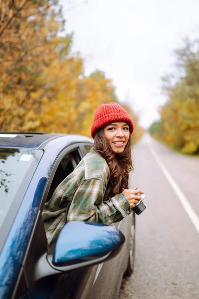 美丽的女人从车窗在相机上拍照 微笑的女人喜欢秋天的天气 生活方式概念 — 图库照片