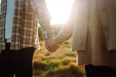 Elin yanından yürü. Genç çift sonbahar havasının tadını çıkarıyor. İnsanlar, yaşam tarzı, rahatlama ve tatil kavramı. 