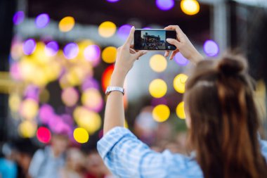 Umumi bir etkinlikte akıllı telefon kullanmak, canlı müzik festivali. Yaz tatili, tatil konsepti. 