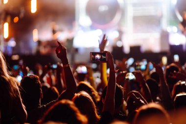 Umumi bir etkinlikte akıllı telefon kullanmak, canlı müzik festivali. Yaz tatili, tatil konsepti. 