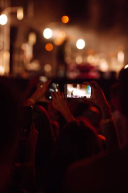 Umumi bir etkinlikte akıllı telefon kullanmak, canlı müzik festivali. Yaz tatili, tatil konsepti. 