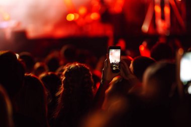 Umumi bir etkinlikte akıllı telefon kullanmak, canlı müzik festivali. Yaz tatili, tatil konsepti. 