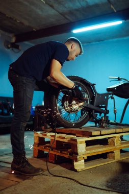 Motosiklet tamiri. Parçalanmış motosiklet. Tamir atölyesinde duran motosikleti tamir etmek. Enstrümanlar ve ekipmanlar. 