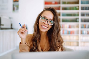 Kablosuz kulaklıklı genç bir kadın laptoptan arıyor. Çevrimiçi konferans, eğitim. Serbest Çalışan, İş, Eğitim Konsepti.