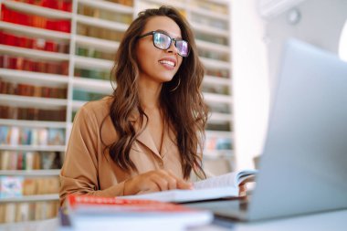 Kablosuz kulaklıklı genç bir kadın laptoptan arıyor. Çevrimiçi konferans, eğitim. Serbest Çalışan, İş, Eğitim Konsepti.
