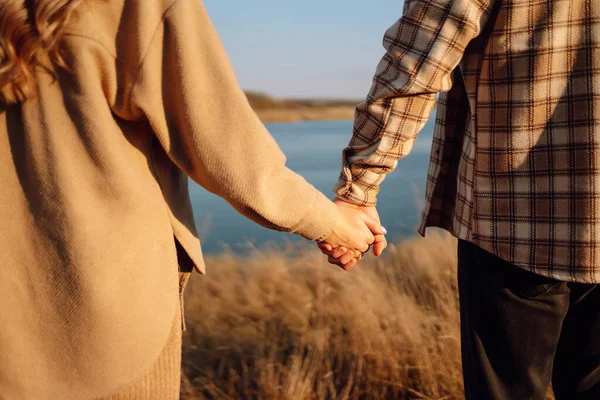 Elin yanından yürü. Genç çift sonbahar havasının tadını çıkarıyor. İnsanlar, yaşam tarzı, rahatlama ve tatil kavramı. 