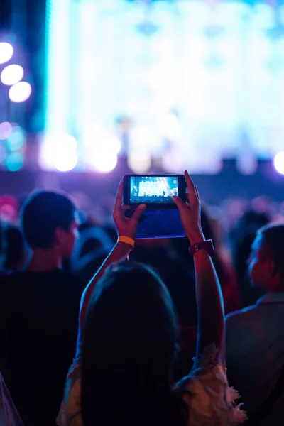 Using a smartphone in a public event, live music festival.  Summer holiday, vacation concept.