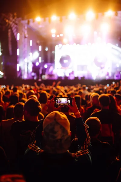 Using a smartphone in a public event, live music festival.  Summer holiday, vacation concept.