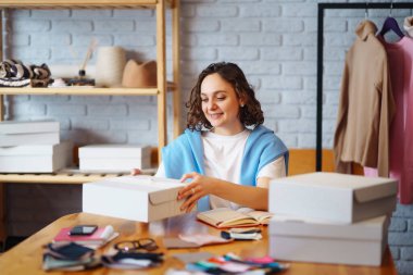 Kargoya verilecek kutuları paketleyen genç bir kadın. nline store, küçük işletme sahibi, satıcı, girişimci, paketleme çantası, posta kutusu.