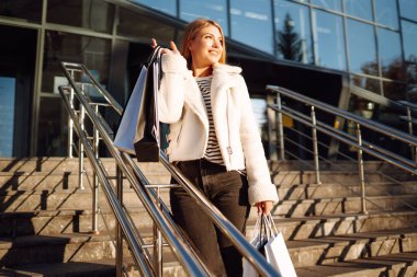 Akıllı telefonlu güzel bir kadın sonbahar haftasonu iyi vakit geçiriyor. İnsanlar, yaşam tarzı, rahatlama ve tatil kavramı. 