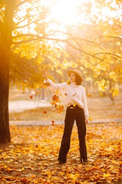 Doğada dinlenen genç bir kadın. Sonbahar. İnsanlar, yaşam tarzı, rahatlama ve tatil kavramı. 