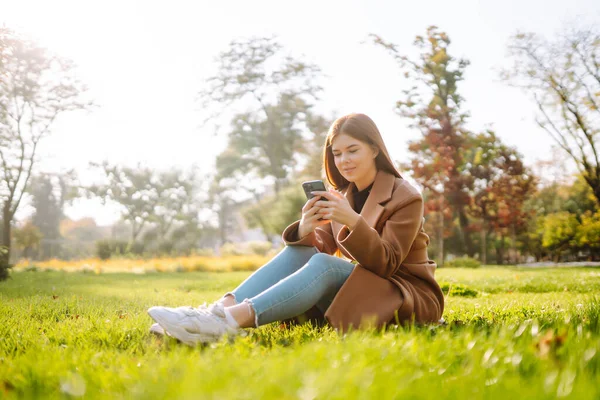 秋の週末に楽しい時間を過ごしているスマートフォンを持つきれいな女性 ライフスタイル リラクゼーション 休暇のコンセプト — ストック写真