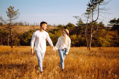 Genç çift doğada dinleniyor. Sonbahar havası. Rahatlama, gençlik, aşk, yaşam tarzı konsepti.