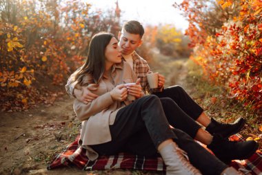 Genç aşık bir çift bir sonbahar günü parkta yürür. Birlikte eğleniyoruz..