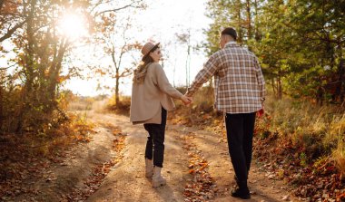 Genç aşık bir çift bir sonbahar günü parkta yürür. Birlikte eğleniyoruz..