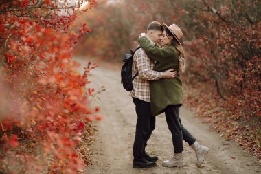 Genç aşık bir çift bir sonbahar günü parkta yürür. Birlikte eğleniyoruz..