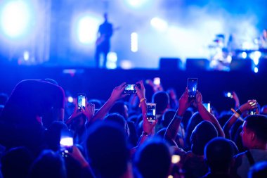 Umumi bir etkinlikte akıllı telefon kullanmak, canlı müzik festivali. Teknolojiler, parti, yaşam tarzı.