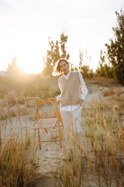Young woman enjoying autumn weather outdoor. Fashion, style concept. People, lifestyle, relaxation and vacations concept.