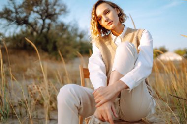 Young woman enjoying autumn weather outdoor. Fashion, style concept. People, lifestyle, relaxation and vacations concept.