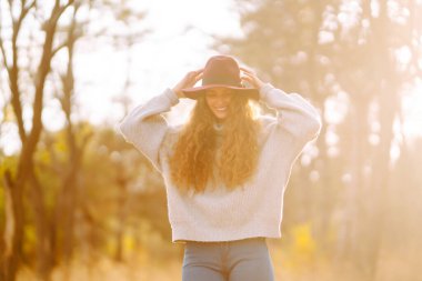 Merhaba Ekim. Sonbaharda şehir parkında moda olan mutlu kadın. Moda, tarz kavramı.