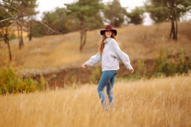 Merhaba Ekim. Sonbaharda şehir parkında moda olan mutlu kadın. Moda, tarz kavramı.
