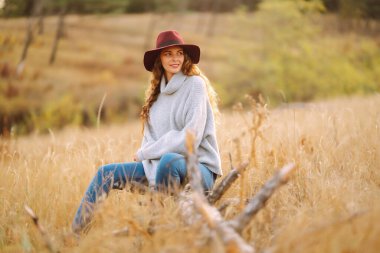 Merhaba Ekim. Sonbaharda şehir parkında moda olan mutlu kadın. Moda, tarz kavramı.