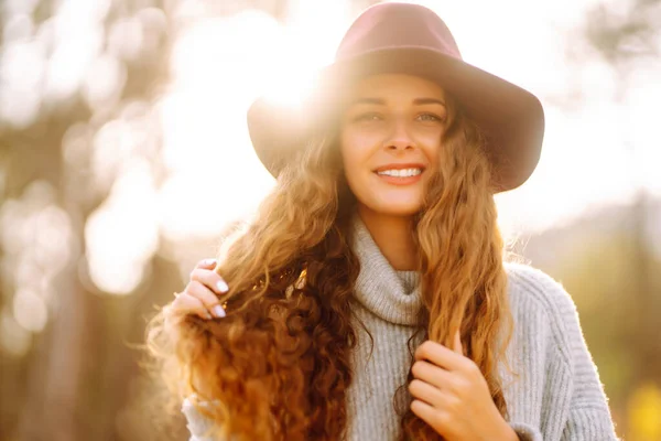 Hello october. Happy trendy woman outdoors in the city park in autumn. Fashion, style concept.