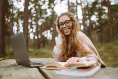 İnternette çalışan ya da parkta oturan güzel bir kadın. İş, blog yazma, serbest çalışma, eğitim kavramı.