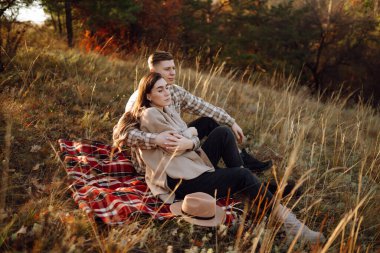 Aşık mutlu çift yeni evliler gündelik giysiler içinde birlikte seyahat ederler, yürüyüş yaparlar ve sonbahar ormanlarında doğada yürürler..