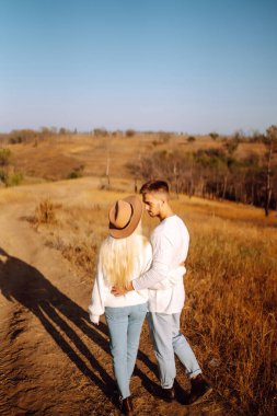 Sevgi dolu bir çift birlikte gezer, yürüyüş yapar ve sonbahar parkında yürür. İnsanlar, yaşam tarzı, rahatlama ve tatil kavramı.