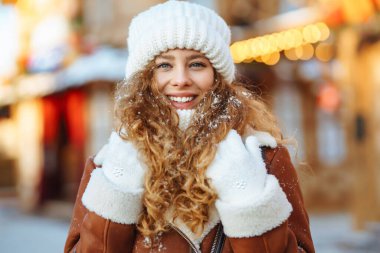 Noel pazarında Noel ışıklarıyla süslenmiş kışın giyimli güzel bir kadın. Tatiller, dinlenme, seyahat konsepti.