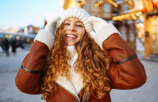穿着冬季风格衣服的漂亮女人在圣诞市场摆设着节日灯饰 旅行概念 — 图库照片