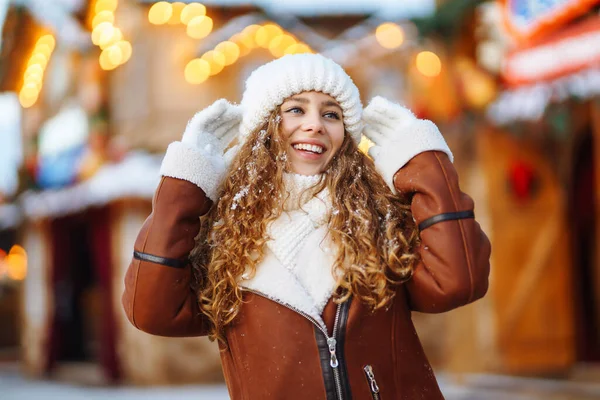 穿着冬季风格衣服的漂亮女人在圣诞市场摆设着节日灯饰 旅行概念 — 图库照片