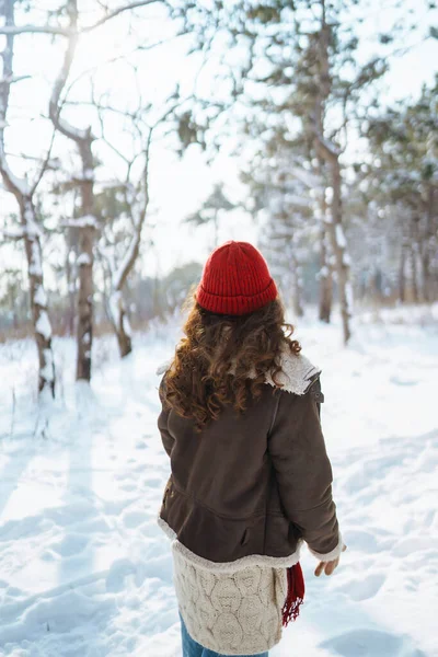 Portrait of young beautiful woman in the winter forest. Christmas, winter holidays concept.