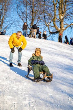 Genç babası, küçük Afrikalı ya da Latin oğluyla kızak sürüyor.