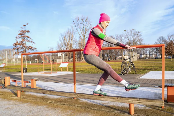 Mujer en forma joven en ropa de fitness colorida de pie en rack manteniendo el equilibrio — Foto de Stock