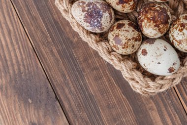 Bir grup bıldırcın yumurtası ahşap masadaki tepsiye konur.