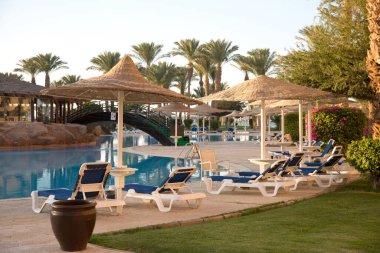 Hurghada, Egypt. Egyptian garden with palm trees in hotel .Swimming pool and accommodation at tropical resort. Buildings, swimming pools and a recreation area by the red sea. All iclusive holidays.
