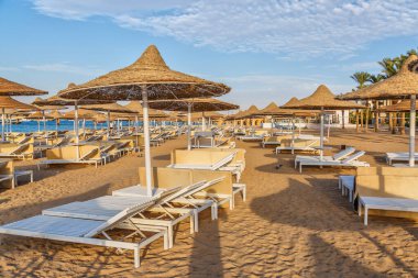 Hurghada, Mısır. Binalar, yüzme havuzları ve Kızıl Deniz kıyısında bir dinlenme alanı. Boş bir sahilde şemsiyeler ve güneş şezlongları. Şemsiyeler ve şemsiyeler.