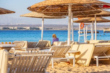 24 Ekim 2021, Hurghada, Mısır. Binalar, yüzme havuzları ve Kızıl Deniz kıyısında bir dinlenme alanı. Boş bir sahilde şemsiyeler ve güneş şezlongları. Şemsiyeler ve şemsiyeler.