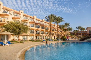 24 Ekim 2021, Hurghada, Mısır. Otel Swimming havuzu ve tropik tatil köyünde konaklama yeri olan Mısır bahçesi. Binalar, yüzme havuzları ve Kızıl Deniz kıyısında bir dinlenme alanı. Hepsi buzlu tatiller..