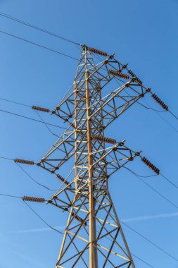 Yüksek voltaj postası. Yüksek voltajlı gökyüzü arka planı. Elektrik konsepti, yüksek voltajlı elektrik iletim pilonu siluetli kule.