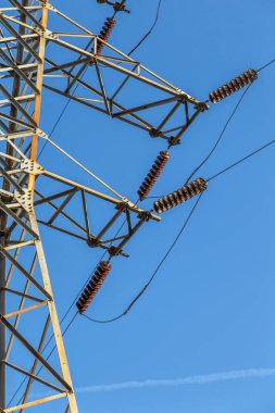 Yüksek voltaj postası. Yüksek voltajlı gökyüzü arka planı. Elektrik konsepti, yüksek voltajlı elektrik iletim pilonu siluetli kule.
